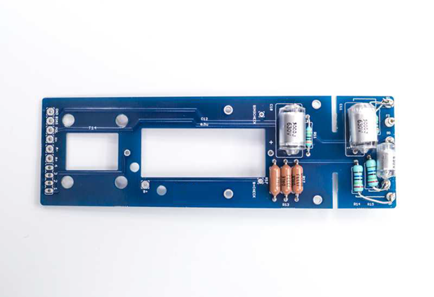 D-12 PCB being cleaned with 91% IPA on an acid brush, focusing on the high-impedance component area.